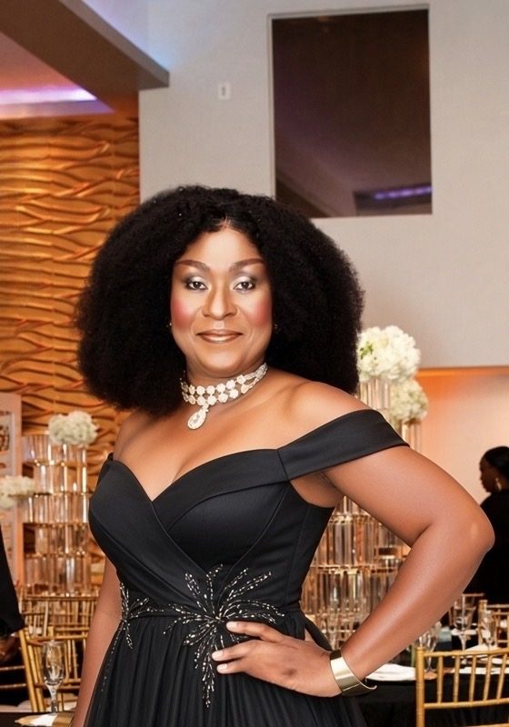 MC Dr Akua in a black off-shoulder formal gown