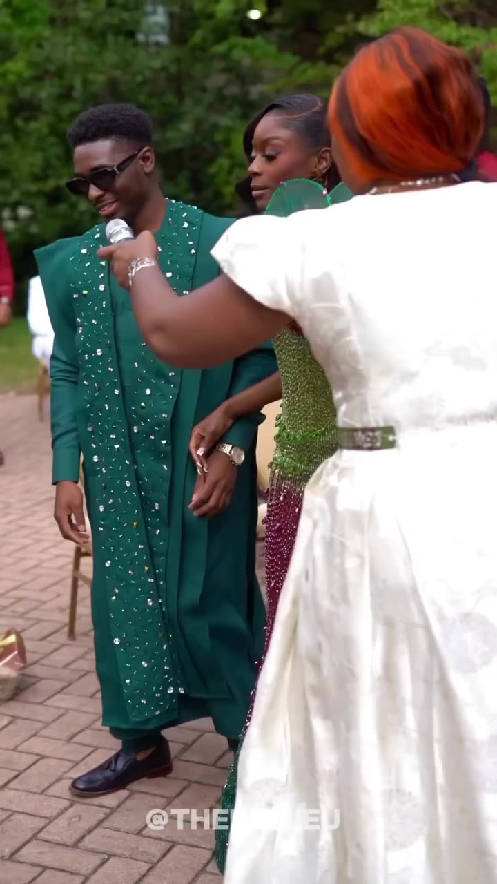 Newlywed couple sharing a moment with MC Dr Akua at the microphone
