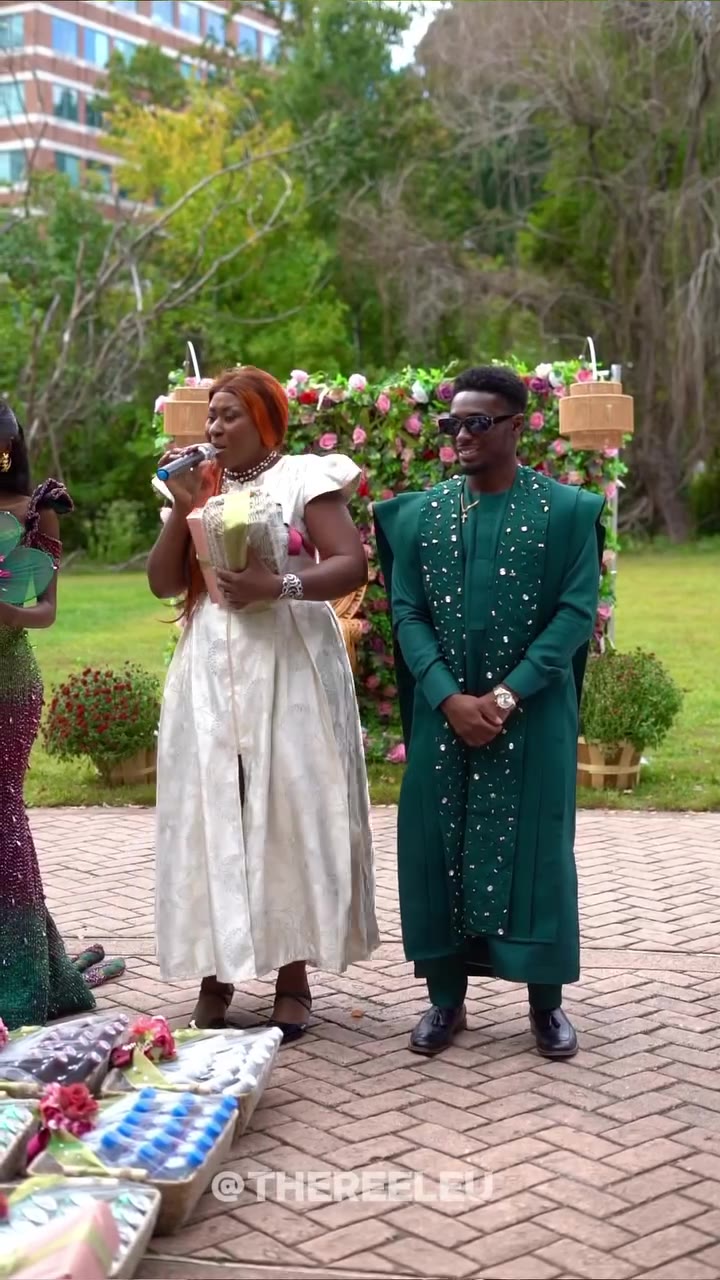 MC Dr Akua speaking into a microphone during a traditional wedding